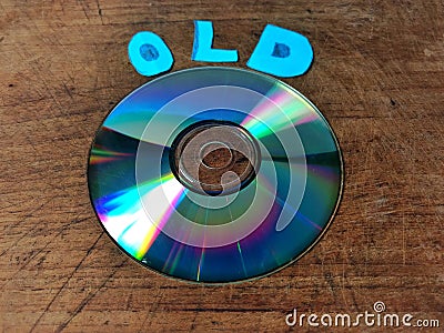 Compact disk on wooden board and the word old. obsolete technology concept Stock Photo