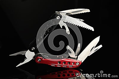 Compact portable colorful multitool on black background Stock Photo