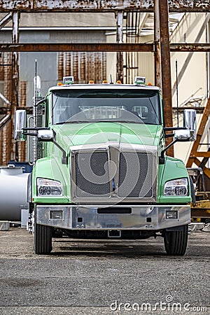Compact powerful day cab big rig semi truck tractor standing on the industrial side parking waiting for the next production load Stock Photo