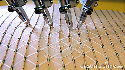 A compact robotic system featuring multiple articulated joints meticulously layering thin sheets of material into a Stock Photo