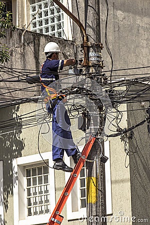 Company employee outsourced maintains an electric power transformer Editorial Stock Photo