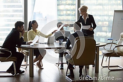 Company executive giving papers presenting new business plan to team Stock Photo