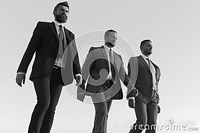 Company leaders make step to success on blue sky background. Business success and cooperation concept. Businessmen with Stock Photo