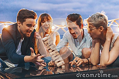 The company of young people playing jenga Stock Photo