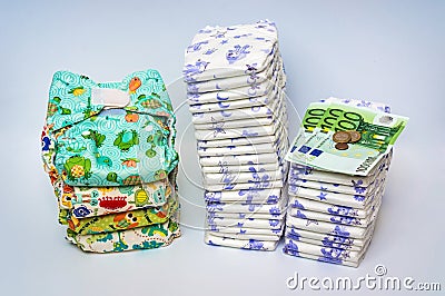 Compare reusable cloth diapers with pile of disposable diapers Stock Photo