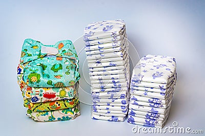 Compare reusable cloth diapers with pile of disposable diapers Stock Photo