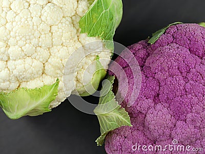 comparson of white and purple cauliflower, top view of different colored vegetables on black background Stock Photo