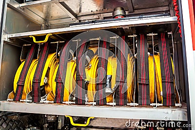 Compartment of rolled up fire hoses on a fire engine. Rescue fire truck equipment. Stock Photo