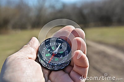 Compass in the hand on a walk. Stock Photo