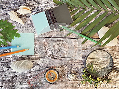 Compass, magnifier, notepad, pencil, sea stones on a textural wooden table Stock Photo