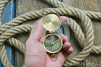 Compass in man hand. Nautical, navigation background. Stock Photo