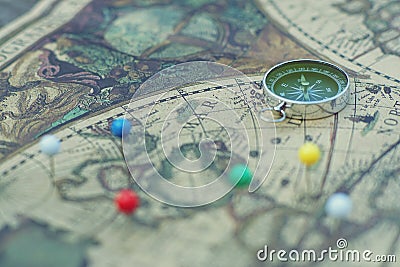 Compass and marking pins on blur vintage map, journey concept Stock Photo