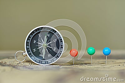Compass and marking pins on blur vintage world map, journey concept Stock Photo