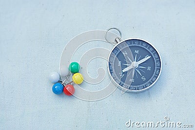 Compass and marking pins on white canvas background Stock Photo
