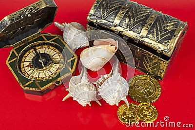 Compass and pirate coins on red background Stock Photo