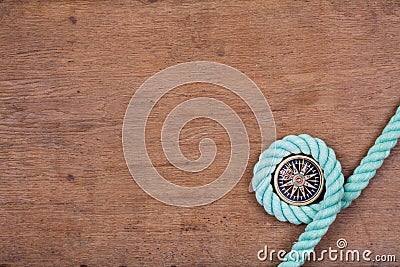 Compass and rope on wooden texture background Stock Photo