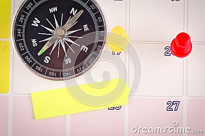 Compass, sticky paper and thumbtacks on calendar for planning concept background. Stock Photo