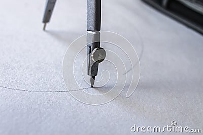 Compasses draw a circle on a sheet of paper Stock Photo