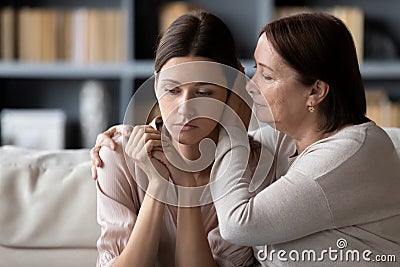 Compassionate middle aged mother comforting stressed upset daughter. Stock Photo