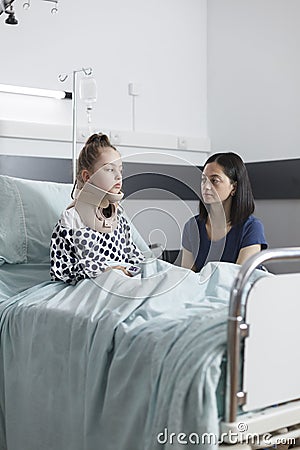 Compassionate uneasy mother spending time in hospital patient room with serious injured child Stock Photo