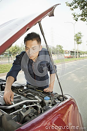 Competent Mechanic Fixing Car by Roadside Stock Photo