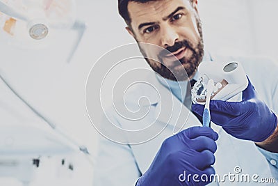 Competent medical worker demonstrating model of jaw Stock Photo