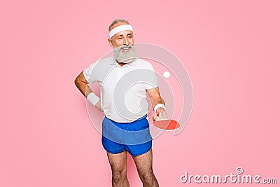 Competetive emotional cool active comic grandpa with beaming grin, with table tennis equipment. Healthcare, weight loss Stock Photo