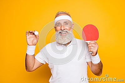 Competetive emotional cool active goofy comic grey haired grandpa with humor grimace and beaming grin, with table tennis Stock Photo