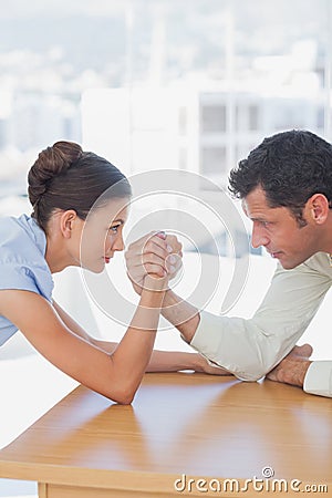 Competitive business people arm wrestling Stock Photo