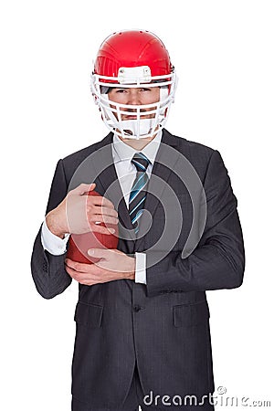 Competitive businessman playing american football Stock Photo
