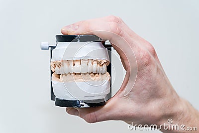Complete full denture in man`s hand. Dental prosthesis design Stock Photo