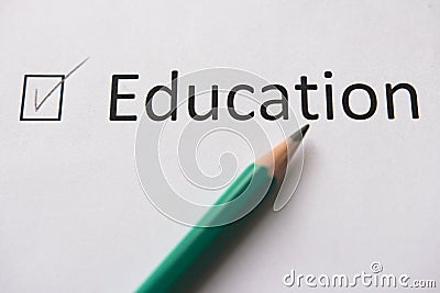 Complete training. To fulfill set goal. word EDUCATION is written on white paper in pencil, marked with tick. Stock Photo