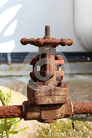 Completely rusted metal pipe connection with strong fully closed valve at abandoned industrial complex Stock Photo