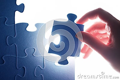 Completing the last piece of jigsaw puzzle. Solution Stock Photo