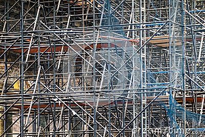 Complicated scaffolding consisting of many poles and struts inside a historic building. Stock Photo