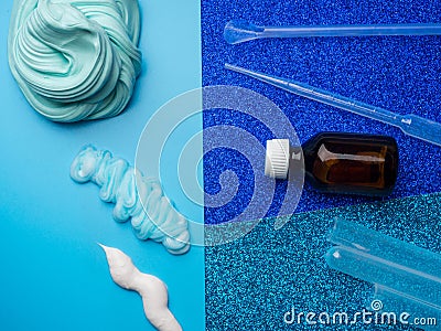 Components to make slime. Child education concept. On blue surface slime, toothpaste, shaving foam, Sodium tetraborate decahydrate Stock Photo