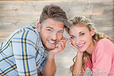 Composite image of attractive young couple lying and smiling at camera Stock Photo