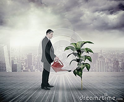 Composite image of businessman holding red watering can Stock Photo