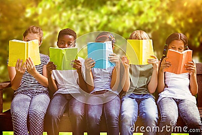 Composite image of children reading books at park Stock Photo
