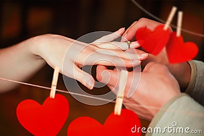 Composite image of close up on man putting on ring during marriage proposal Stock Photo