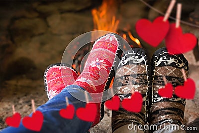 Composite image of close up of romantic legs in socks in front of fireplace Stock Photo