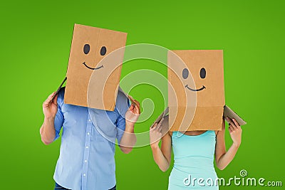 Composite image of couple wearing emoticon face boxes on their heads Stock Photo