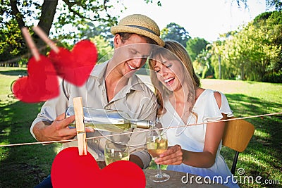 Composite image of cute couple drinking white wine together outside Stock Photo