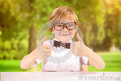 Composite image of cute pupil showing thumbs up Stock Photo