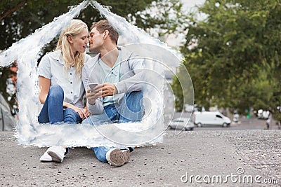 Composite image of cute young couple sitting on skateboard kissing Stock Photo