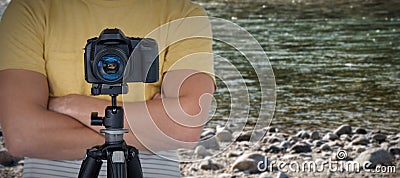 Composite image of digital camera on tripod against photographer Stock Photo