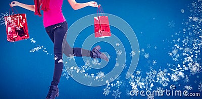 Composite image of festive blonde carrying gift bags Stock Photo