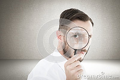 Composite image of geeky businessman looking through magnifying glass Stock Photo
