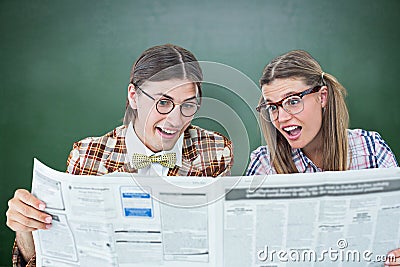 Composite image of geeky hipsters reading the newspaper Stock Photo