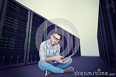 Composite image of handsome hipster using tablet pc Stock Photo